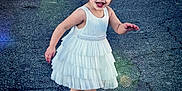 Journii is registered to the contest to win money with this photo: child, girl, smiling, white_dress, sandals, outdoor, asphalt, happy, playful, hair_accessory, cute, person, fashion, summer, feet, standing, young, fun, joy, portrait
