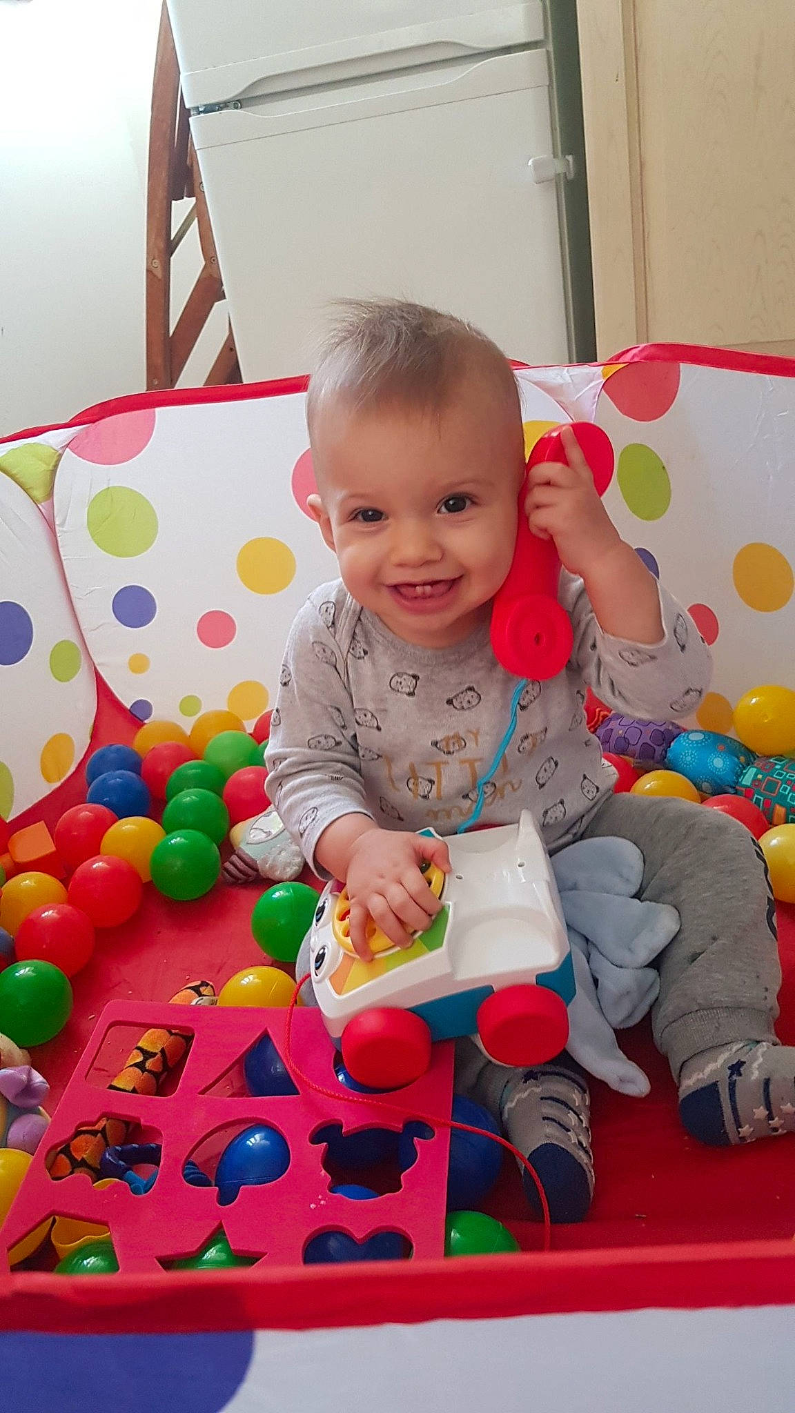 Luciano participe au concours pour gagner de l'argent avec cette photo : baby, baby_laughing, baby_playing_with_toys, baby_products, baby_toddler_clothing, baby_toys, child, joy, mouth, nose, person, play, sitting, sock, toddler, toy