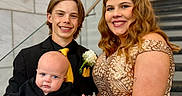 Koleson is registered to the contest to win money with this photo: baby, child, young_adult, woman, man, formal_wear, dress, suit, tie, flower_corsage, stairs, hand_holding, smiling, portrait, indoor, people, family, happy, hairstyle, skin