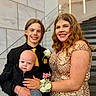 baby, child, young_adult, woman, man, formal_wear, dress, suit, tie, flower_corsage, stairs, hand_holding, smiling, portrait, indoor, people, family, happy, hairstyle, skin