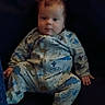 baby, infant, child, dinosaur_onesie, onesie, sitting, chair, indoor, portrait, face, eyes, red_hair, wide_eyed, hands, feet, dark_background, furniture, cute, casual_clothing, photograph