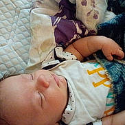 Aidan is registered to the contest to win money with this photo: baby, sleeping, infant, portrait, face, closed_eyes, blanket, cozy, bed, bedding, pillow, indoors, resting, peaceful, clothing, onesie, arm, hand, cute, nap