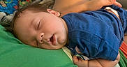 Aidan joined the competition — help win amazing prizes! baby, sleeping, infant, portrait, curled_up, blue_clothing, green_cushion, indoor, resting, peaceful, face, closed_eyes, dark_hair, child, nap, soft_surface, adult_hand, cozy, candid_photo, family
