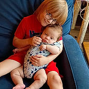 Daniel joined the competition — help win amazing prizes! armchair, baby, bare_feet, blond_hair, blue_chair, brown_hair, child, cuddling, glasses, holding_baby, home, indoor, infant, mickey_mouse, portrait, red_clothing, siblings, sitting, smiling, 抱抱