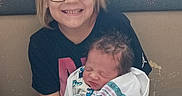 Daniel is registered to the contest to win money with this photo: baby, blonde_hair, child, clothing, couch, family, glasses, hands, holding_baby, home, indoor, infant, newborn, photography, portrait, sibling, sitting, sleeping, smiling, swaddled