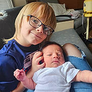 Daniel joined the competition — help win amazing prizes! child, newborn, baby, siblings, portrait, indoor, couch, bed, glasses, smiling, infant, white_onesie, blue_shirt, blond_hair, family, cuddling, sitting, home, photography, hospital_equipment