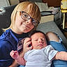 child, newborn, baby, siblings, portrait, indoor, couch, bed, glasses, smiling, infant, white_onesie, blue_shirt, blond_hair, family, cuddling, sitting, home, photography, hospital_equipment