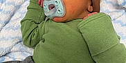 Khaza is registered to the contest to win money with this photo: baby, newborn, sleeping, pacifier, hat, green_shirt, gray_pants, blanket, soft, cozy, infant, resting, cute, child, small, peaceful, clothing, bed, portrait, indoors