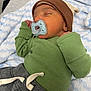 baby, newborn, sleeping, pacifier, hat, green_shirt, gray_pants, blanket, soft, cozy, infant, resting, cute, child, small, peaceful, clothing, bed, portrait, indoors