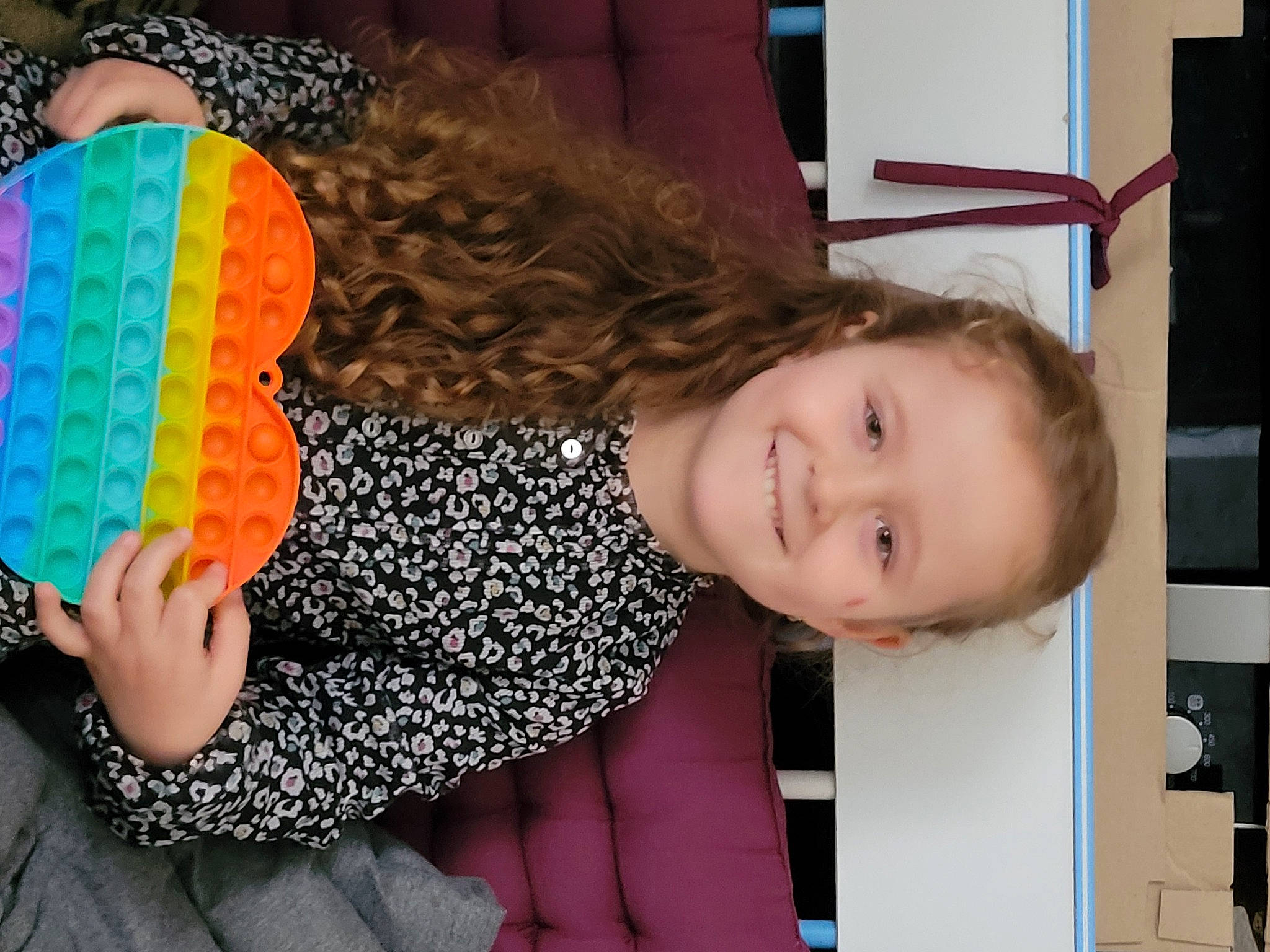 Lynna participe au concours pour gagner de l'argent avec cette photo : child, comfort, fun, hair, hairstyle, happy, human_body, human_leg, joy, knee, neck, organ, pattern, people, person, room, sitting, sleeve, smile, thigh