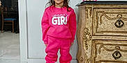 Dawn is registered to the contest to win money with this photo: child, dresser, face, floor_tiles, furniture, girl, hair, home, indoor, pants, person, pink_clothing, pink_shoes, plush, smile, standing, sweatshirt, toy, vintage_furniture, wall