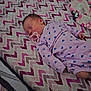 Karissa is registered to the contest to win money with this photo: baby, newborn, sleeping, pacifier, blanket, zigzag_pattern, purple_clothing, heart_pattern, infant, bed, resting, cute, child, soft, cozy, indoors, portrait, peaceful, toddler, sleep