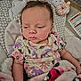 Karissa is registered to the contest to win money with this photo: baby, baby_clothes, blanket, bunny_toy, closeup, comfort, cushion, face, floral_clothing, head, indoors, infant, infant_seat, person, portrait, resting, sleepy, soft_toy, toddler, warning_label