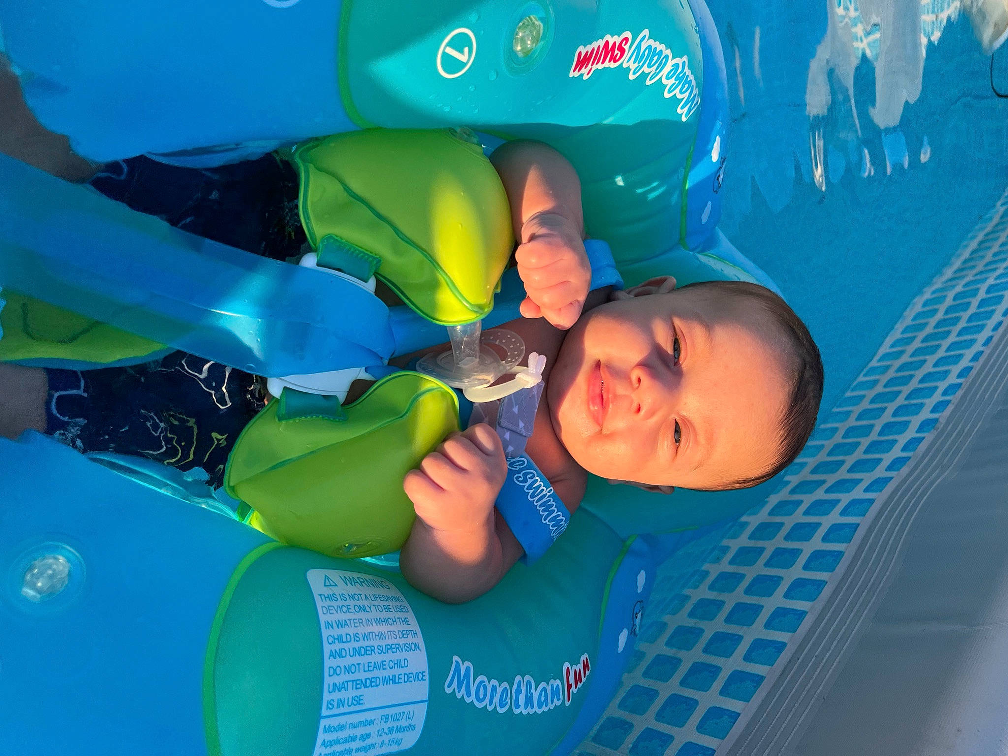 Kayson is registered to the contest to win money with this photo: aqua, azure, child, electric_blue, fun, happy, inflatable, leisure, person, personal_protective_equipment, plastic, play, recreation, room, smile, t_shirt, toddler, water, world