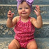 baby, child, toddler, girl, headband, bow, romper, red_clothing, purple, steps, outdoor, smiling, hands, portrait, cute, skin, sitting, expression, face, playful
