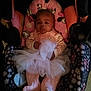 baby, infant, car_seat, pink_clothing, tutu, blanket, floral_pattern, footed_pajamas, child, cute, portrait, indoors, soft_lighting, seated, adorable, warm_colors, comfort, young_child, baby_girl, resting