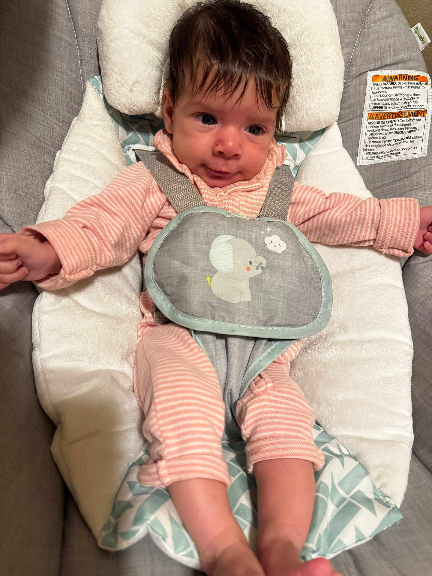 Evangeline is registered to the contest to win money with this photo: baby, infant, child, face, pink_clothing, striped_clothing, baby_seat, cushion, safety_harness, indoor, cute, small_hands, small_feet, soft_toys, gray_background, closeup, portrait, expression, hair, eyes