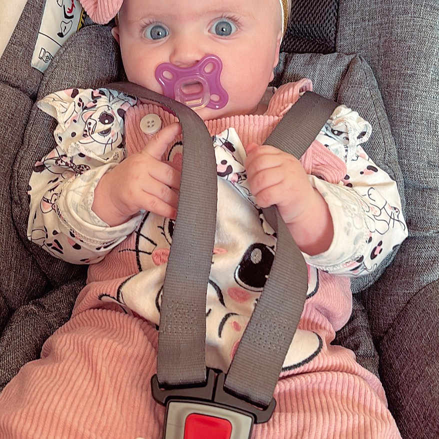 Ariana participe au concours pour gagner de l'argent avec cette photo : baby, big_eyes, blue_eyes, bow, buckle, car_seat, child, closeup, corduroy, fabric_texture, hands, harness, headband, infant, onesie, pacifier, pink_clothing, portrait, seat_belt, surprised_expression
