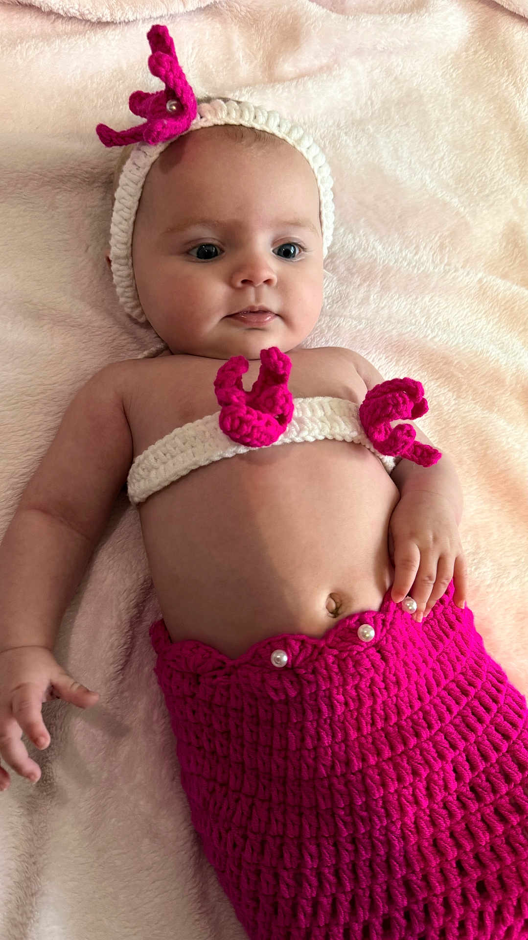 Ariana a rejoint le concours — aidez-le/la à gagner de superbes lots ! baby, infant, crocheted_clothing, mermaid_costume, headband, pink, white, blanket, lying_down, cute, child, soft_texture, hand, belly_button, portrait, indoors, young_child, fashion, costume, adorable