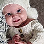 Ariana participe au concours pour gagner de l'argent avec cette photo : baby, smiling, knitted_hat, white_clothing, buttons, hands, blanket, texture, soft, cute, infant, portrait, closeup, happy, cozy, indoor, skin, face, eyes, child
