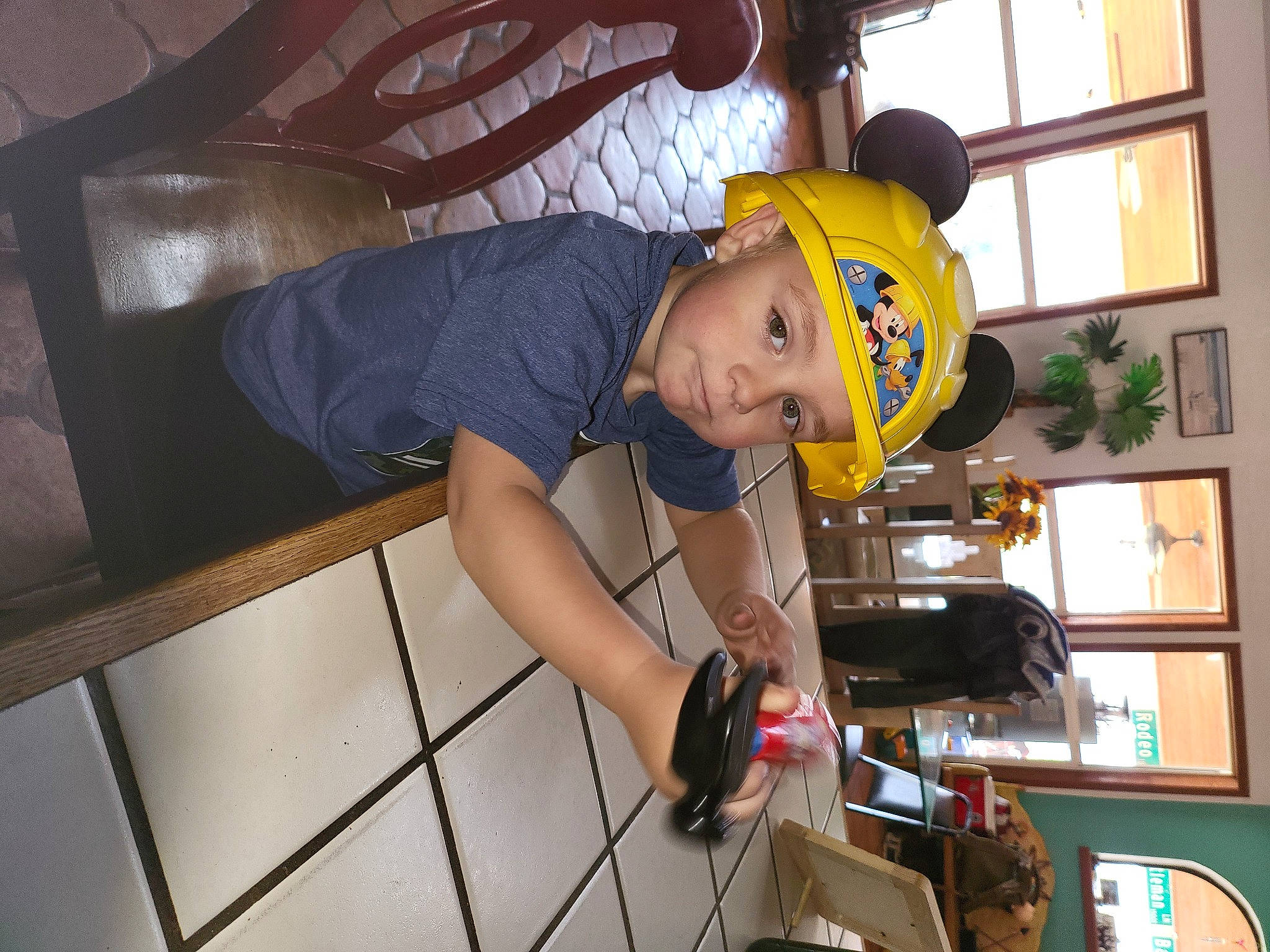Drew is registered to the contest to win money with this photo: arm, baby, baseball_cap, child, elbow, engineering, fun, hat, headwear, helmet, human_leg, leisure, machine, person, personal_protective_equipment, recreation, room, shorts, t_shirt, thigh