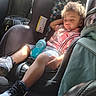 black_shoes, car_interior, car_seat, child, clothing, curly_hair, daylight, plaid_shirt, relaxed, seat, seatbelt, shoes, shorts, sippy_cup, sleeping, sunlight, toddler, travel, vehicle, white_shoes