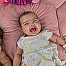 baby, infant, child, smiling, laughing, portrait, close_up, lying_down, pink_cushion, stuffed_animal, zebra_toy, floral_dress, baby_clothing, indoors, playful, happy, face, arms, legs, photography