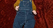 Wren is registered to the contest to win money with this photo: baby, infant, child, portrait, smiling, lying_down, denim_overalls, mustard_shirt, blanket, burgundy_background, toy_balls, colorful_toys, blue_ball, orange_ball, red_ball, bare_feet, indoors, milestone_photo, decorative_lettering, happy