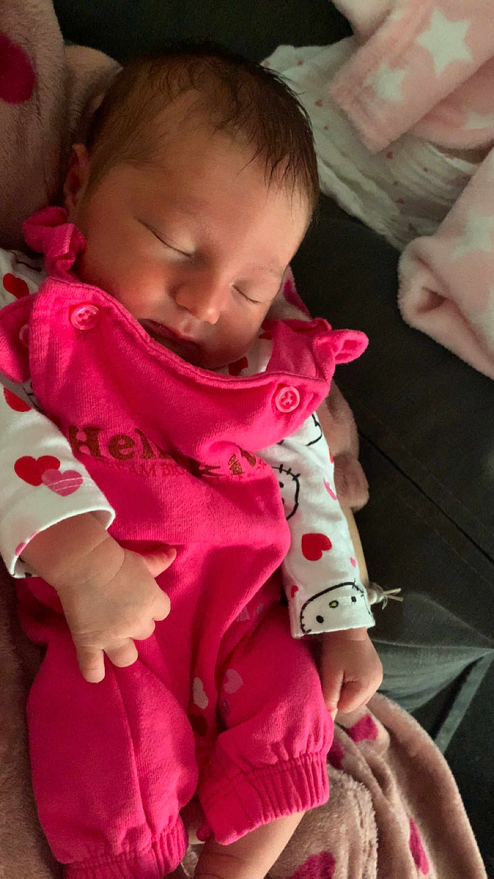 Evie-Mae is registered to the contest to win money with this photo: baby, sleeping, pink_overalls, white_shirt, hearts_pattern, blanket, soft_texture, infant, cute, peaceful, hand, face, closed_eyes, cozy, warm, child, newborn, resting, indoors, comfort