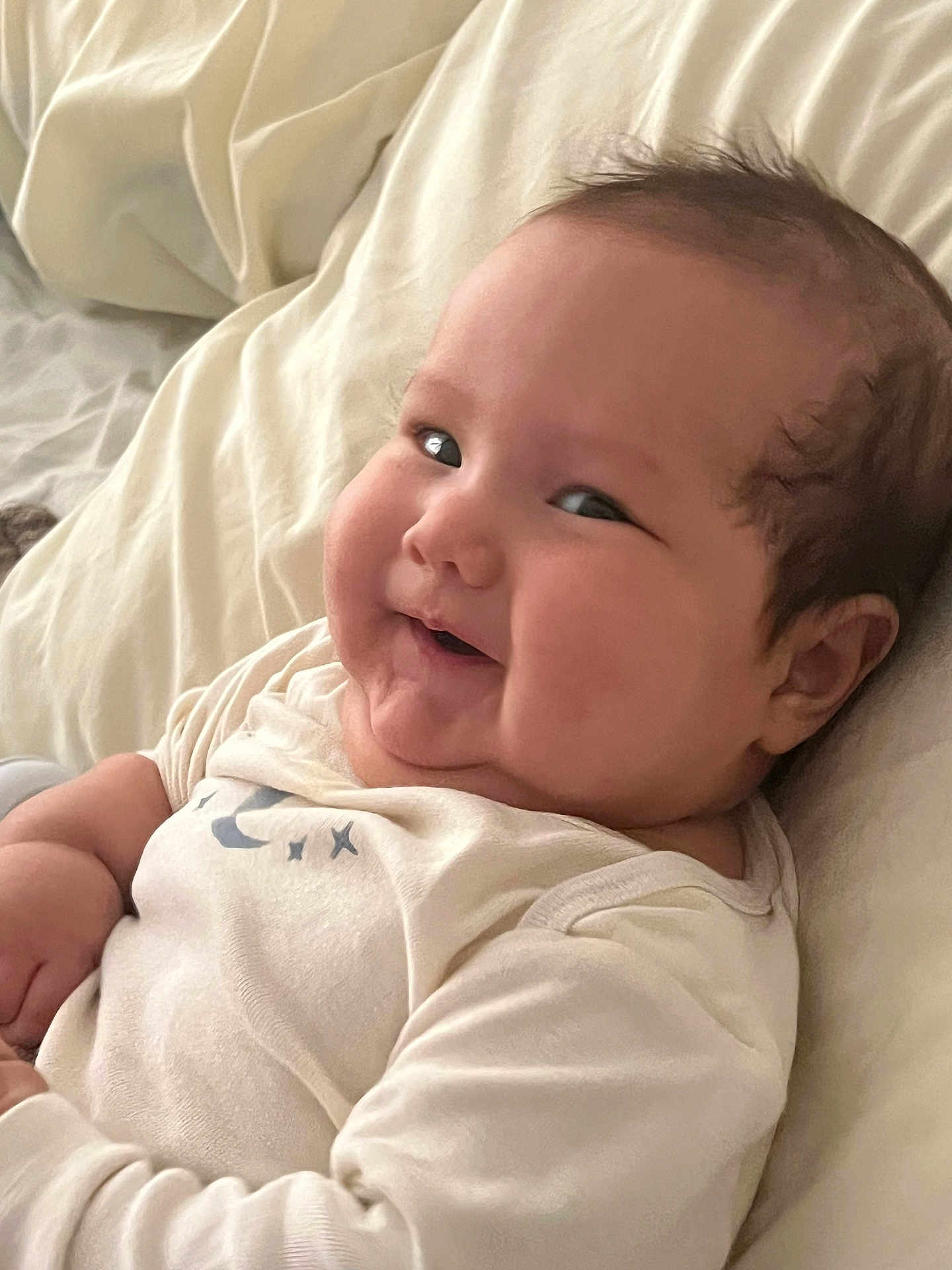 Viggo joined the competition — help win amazing prizes! baby, infant, smile, face, cheeks, bed, blanket, clothing, cute, lying_down, skin, head, hair, person, indoors, soft, expression, baby_garments, cozy, happy
