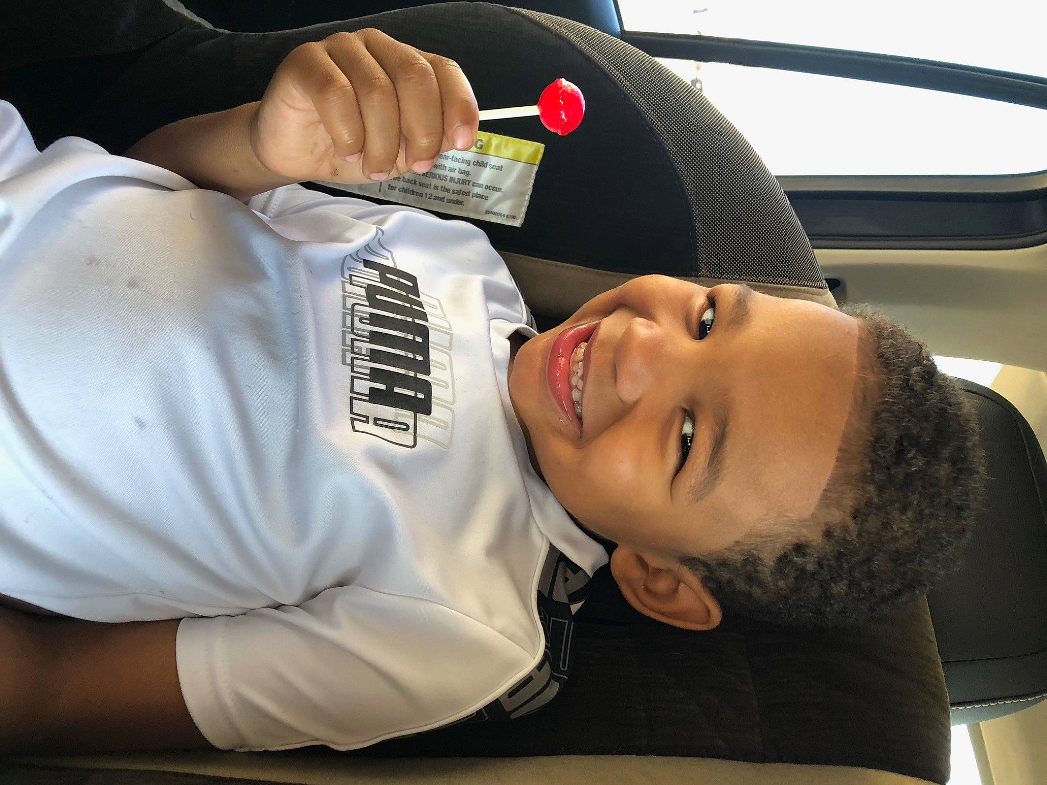 Karter is registered to the contest to win money with this photo: auto_part, automotive_design, automotive_exterior, automotive_lighting, automotive_tire, automotive_wheel_system, bumper, car, car_seat, eyewear, family_car, hood, joy, luxury_vehicle, mid_size_car, motor_vehicle, person, personal_luxury_car, smile, steering_wheel