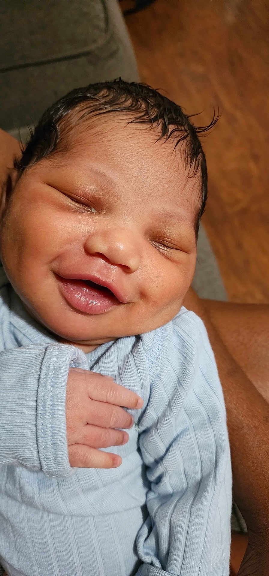 Brezdin is registered to the contest to win money with this photo: baby, newborn, smiling, face, hand, clothing, blue_outfit, skin, person, infant, sleeping, closeup, cute, happy, child, portrait, human, toddler, resting, warm_lighting