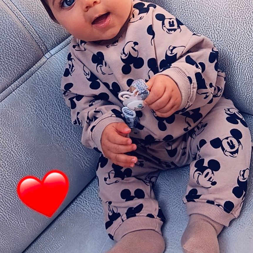 Leyssen a rejoint le concours — aidez-le/la à gagner de superbes lots ! baby, blue_eyes, child, clothing, comfort, couch, cute, expression, face, footwear, hand, indoor, infant, love_emoji, mickey_mouse, pacifier, sitting, sock, sofa, texture