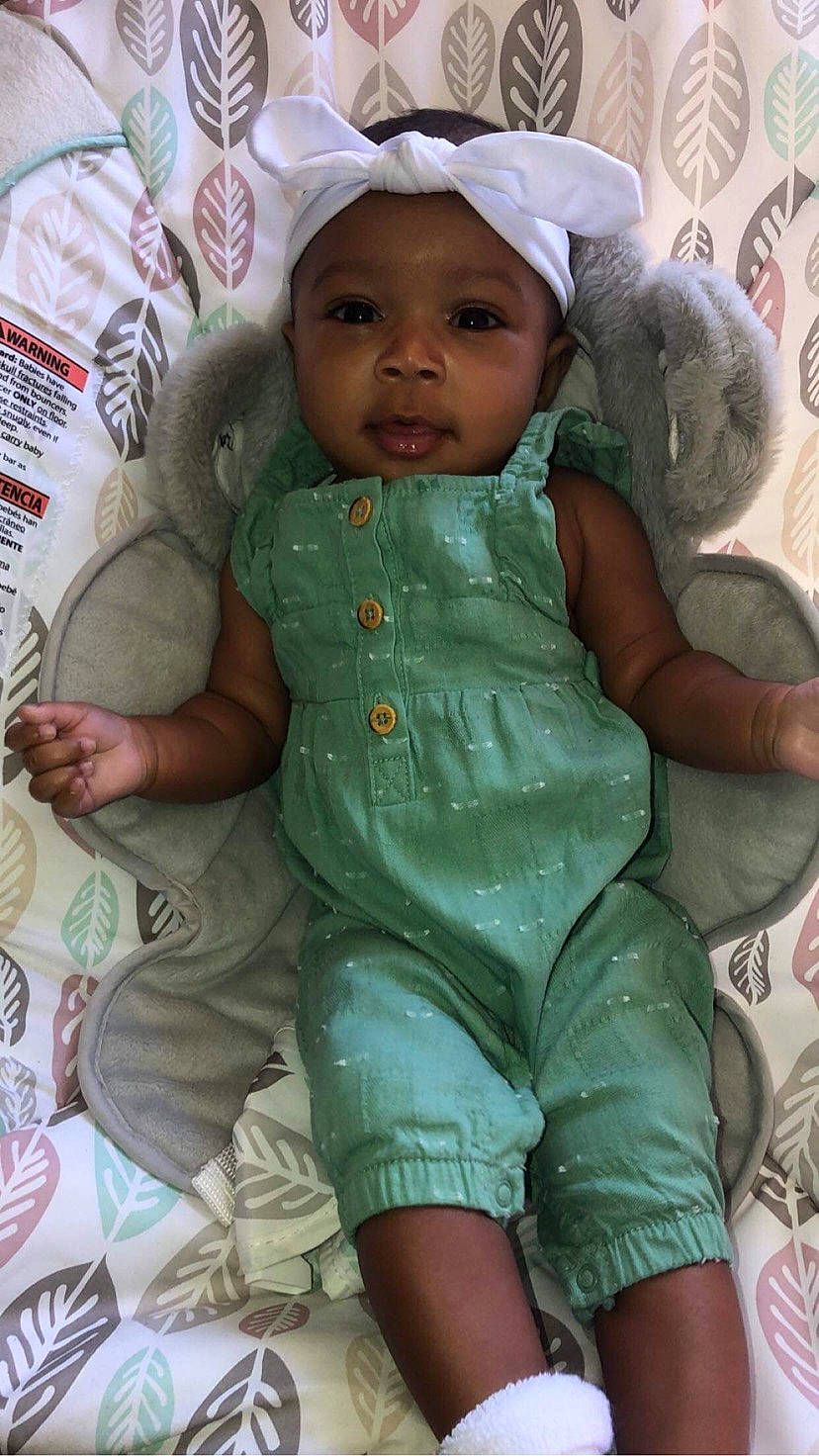 Mia is registered to the contest to win money with this photo: arm, baby, baby_products, baby_safety, baby_toddler_clothing, cheek, child, comfort, eye, face, finger, hand, head, headwear, iris, linens, person, pink, skin, sleeve