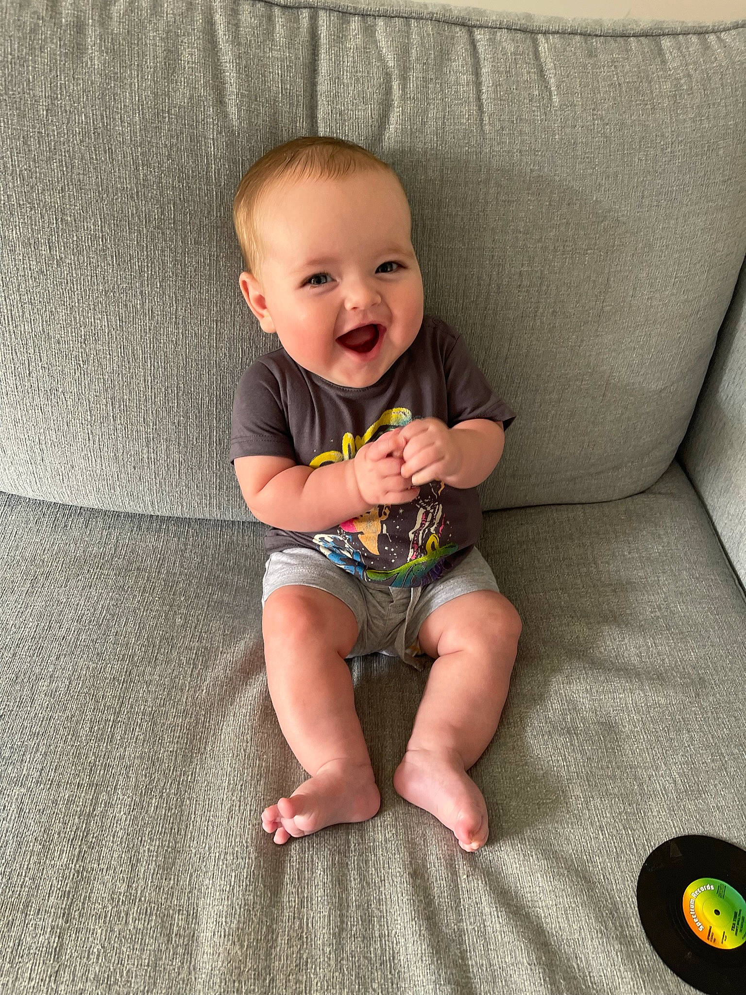Theo joined the competition — help win amazing prizes! baby, baby_toddler_clothing, cheek, child, comfort, couch, eye, face, finger, flash_photography, flooring, head, human_leg, knee, leg, person, skin, sleeve, smile, t_shirt