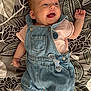 Esmée a rejoint le concours — aidez-le/la à gagner de superbes lots ! baby, infant, smiling, denim_overalls, pink_shirt, lying_down, patterned_blanket, happy, cute, child, face, small_baby, clothing, portrait, closeup, person, skin, head, hand, expression