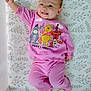 baby, infant, smiling, pink_clothing, winnie_the_pooh, tiger, eeyore, piglet, lying_down, mattress, patterned_bedding, cute, happy, child, portrait, indoors, sleepwear, raised_arm, small_feet, cheerful