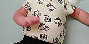 Laynie is registered to the contest to win money with this photo: baby, infant, cute, hello_kitty, onesie, black_shorts, toy, soft_toy, lying_down, curious, expression, indoor, child, young, face, skin, chubby, arms, legs, playful