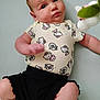 Laynie is registered to the contest to win money with this photo: baby, infant, cute, hello_kitty, onesie, black_shorts, toy, soft_toy, lying_down, curious, expression, indoor, child, young, face, skin, chubby, arms, legs, playful