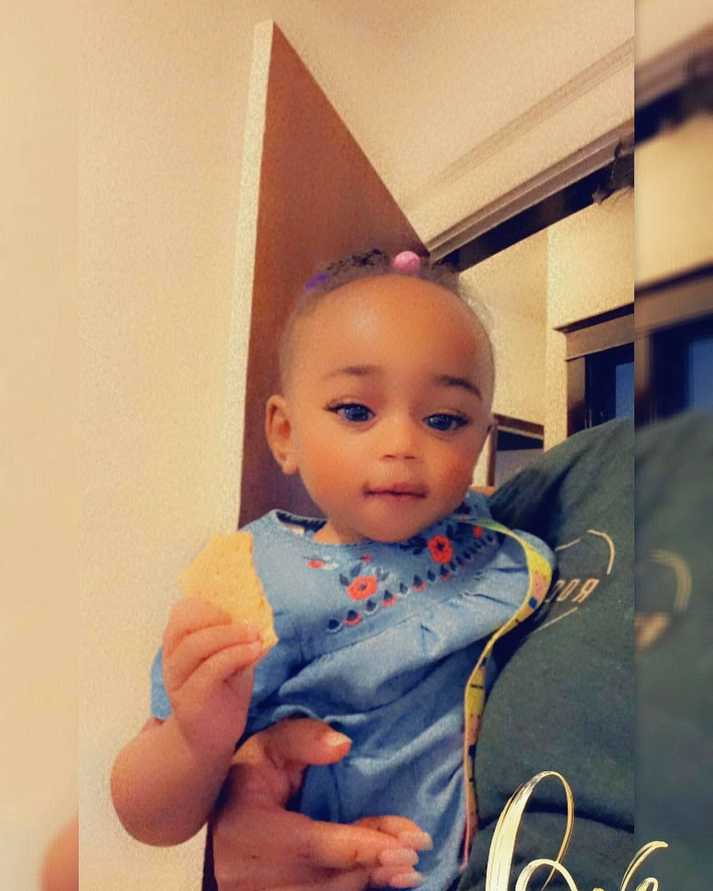 Imani is registered to the contest to win money with this photo: abdomen, baby, baby_toddler_clothing, cheek, chest, child, electric_blue, eyelash, fashion_accessory, fashion_design, fun, gesture, hand, happy, neck, person, sitting, sleeve, t_shirt, thumb