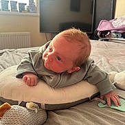 Luca-Lee is registered to the contest to win money with this photo: baby, bed, blanket, casual, clothing, curious, face, hand, home, indoors, infant, pillow, radiator, room, sleepwear, soft_lighting, television, toy, window, young_child