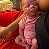 arm, baby, closeup, comfort, couch, curly_hair, human, indoor, infant, newborn, onesie, peaceful, person, portrait, red_blanket, relaxation, resting, skin, sleeping, soft_lighting