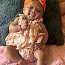Syomii joined the competition — help win amazing prizes! baby, blanket, bow, child, cute, gray, headband, indoors, infant, orange, person, pillow, pink, portrait, ruffles, sitting, smiling, soft_texture, striped_clothing, tongue_out