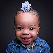 Camryn is registered to the contest to win money with this photo: toddler, child, smiling, portrait, denim_shirt, flower_accessory, cute, happy, face, headshot, studio, dark_background, jewelry, person, young_child, innocence, closeup, fashion, baby, expression