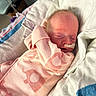 newborn, baby, infant, sleeping, hospital, nasal_tube, pink_outfit, blanket, medical, fragile, resting, cute, soft, delicate, person, child, healthcare, patient, cozy, indoors