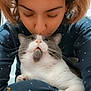 person, cat, pajamas, polka_dot, indoor, affection, close_up, pet, cute, cozy, lap, hair, whiskers, closed_eyes, love, comfort, face, fur, nose, hand