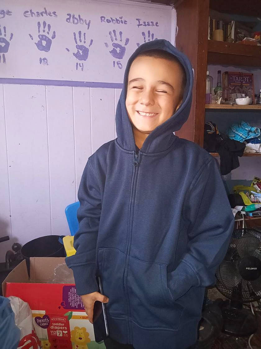 Lucas is registered to the contest to win money with this photo: beanie, cook, cooking, customer, fun, happy, hoodie, jacket, job, joy, laugh, person, personal_protective_equipment, room, shelf, shelving, sitting, sleeve, smile, t_shirt