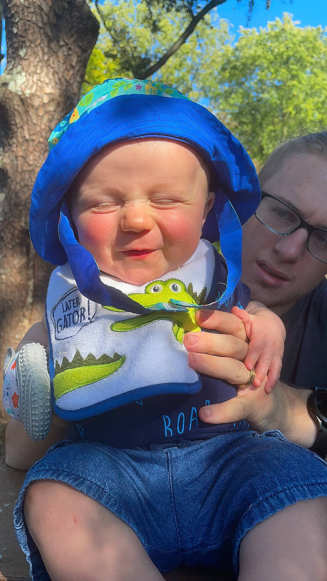 Emmerson is registered to the contest to win money with this photo: baby, baby_toddler_clothing, blue, child, cool, face, fun, gesture, grass, happy, headgear, headwear, leisure, people_in_nature, person, product, skin, smile, summer, toddler