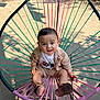 baby, child, outdoor, chair, colorful, woven_chair, clothing, cute, expression, person, footwear, sunlight, garden, nature, sitting, portrait, casual_wear, happy, young_child, daylight