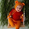 Hadryel participe au concours pour gagner de l'argent avec cette photo : baby, child, costume, cute, greenery, happy, headwear, honey_dipper, indoor, infant, knitted_outfit, leaves, orange, plush_toy, portrait, red, smiling, swing, winnie_the_pooh, wood